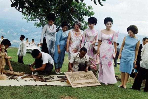 24 Oct 1966, Tagaytay, Philippines --- While their husbands occupied themselves at a summit meeting on the war in Viet Nam, these ladies kept busy touring and meeting with natives.  Here at the lovely Taal Vista Lodge, the ladies stop to admire Filipino embroidery work.  They are standing at back, left to right: Mrs. Nguyen Cao Ky, Mrs. Lyndon B. Johnson,  and Mrs. Ferdinand Marcos. --- Image by © Bettmann/CORBIS