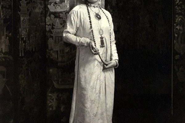 Princess Achille Murat (married to Prince Achille Murat) wearing traditional costume of an Indo-Chinese lady: long-sleeved, waistless satin dress with floral embroidery, beaded necklace, two medallion necklaces, hair pulled back in a scarf, and satin slippers *** Local Caption *** Princess Achille Murat;

-------
Princess Achille Murat (married to Prince Achille Murat) wearing traditional costume of an Indo-Chinese lady: long-sleeved, waistless satin dress with floral embroidery, beaded necklace, two medallion necklaces, hair pulled back in a scarf, and satin slippers
November 03, 1926| Credit: Edward Steichen