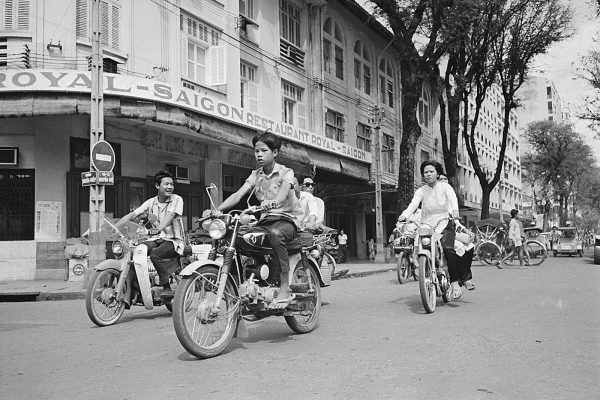 18 Nov 1967, Saigon, South Vietnam --- An Afternoon in Saigon. To the youthful South Vietnamese, the motorcycle is almost a status symbol. Here, a group of youngsters zooms down a major Saigon thoroughfare on the bikes. --- Image by © Bettmann/CORBIS