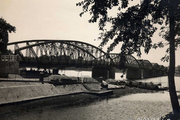 Hué, 1931  Le pont Clemenceau sur la Rivière des Parfums

Notice : Renseignements donnés par lingénieur Desmarets : « Longueur 400 m en 6 travées. Chaussée centrale 5m 62. 2 trottoirs en encorbellement de 1m 95 ». Sur le pont Clemenceau, voir AP00731. Sur la Rivière (ou Fleuve) des Parfums, voir AP2486. La vue est prise depuis la rive droite du fleuve, du côté de la ville européenne, à lentrée de lhôtel Morin. Un petit bassin et un quai sont aménagés au pied du pont, où les bateaux naviguant sur le fleuve peuvent débarquer passagers et marchandises. 

http://www.aavh.org/?p=1670