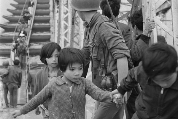 Photo: Art Greenspon
(Caption from book)
Refugees fleeing from the northern side of the Perfume River cross a pontoon bridge connecting the downed spans of the destroyed bridge. Moments later, the Army of the Rep. of Vietnam (ARVN) removed the temporary bridge to prevent more refugees from crossing to the already crowded southern section of Hué. 
March 1968 | Hué

------------------

Refugees flee from the northern side of the Perfume River. March 1968 (Image credit: Art Greenspon)

https://news.stanford.edu/2018/08/23/resurfacing-tabloid-vietnam-war/