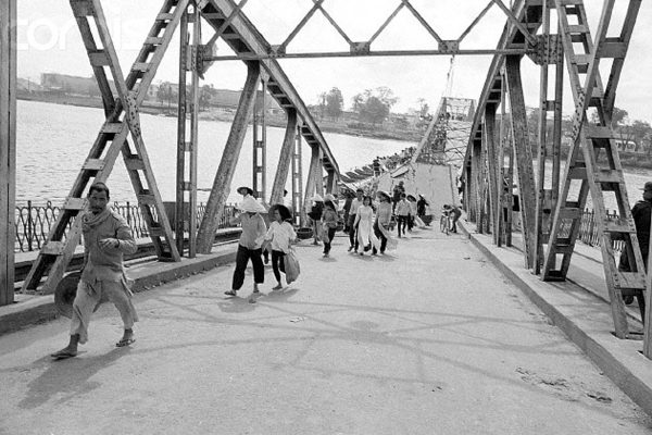 22 Mar 1968, Hue, South Vietnam --- Pedestrians carefully cross the makeshift center span of a bridge that has been partially destroyed during the Vietnam War near Hue, South Vietnam. --- Image by © Bettmann/CORBIS