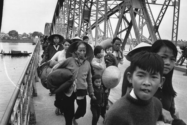 19th February 1968:  A group of Vietnamese refugees crossing a bridge over the Perfume River.  (Photo by Terry Fincher/Express/Getty Images)