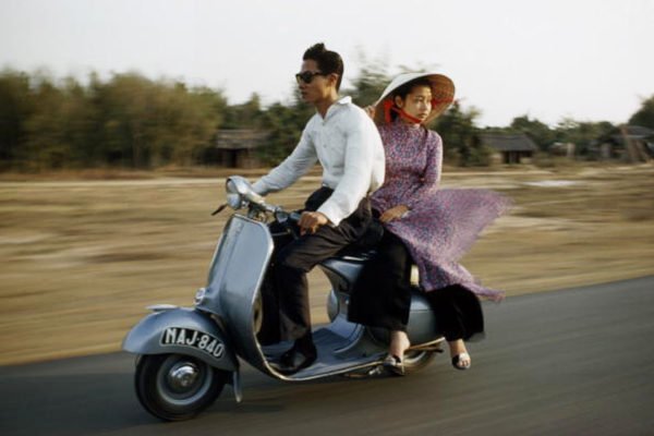 VIETNAM - OCTOBER 10:  A nattily dressed young couple zip down the road on a motor scooter, Ho Chi Minh City, Vietnam  (Photo by Wilbur E. Garrett/National Geographic/Getty Images)